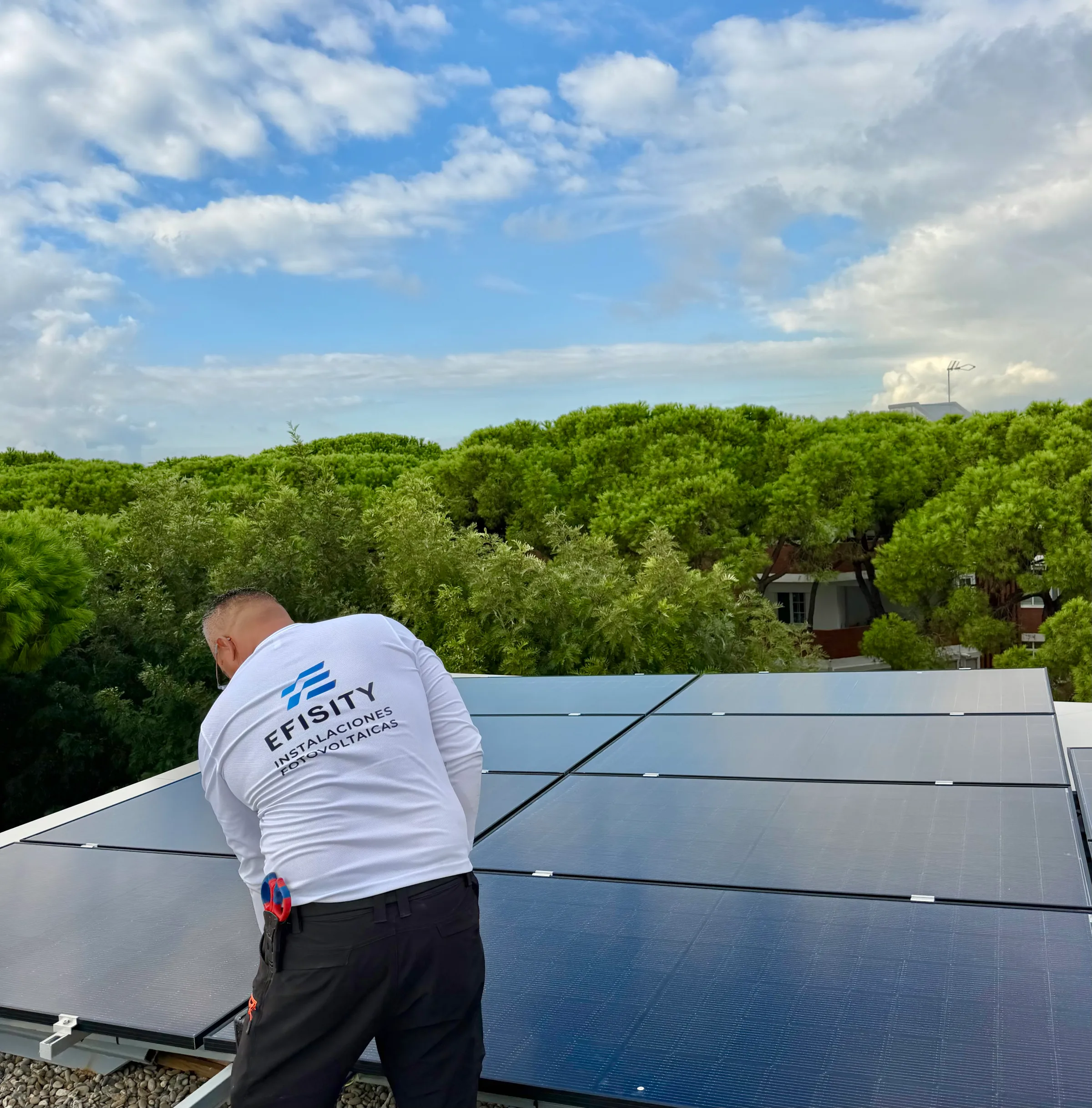 Instalador de Efisity revisando placas solares en una cubierta plana
